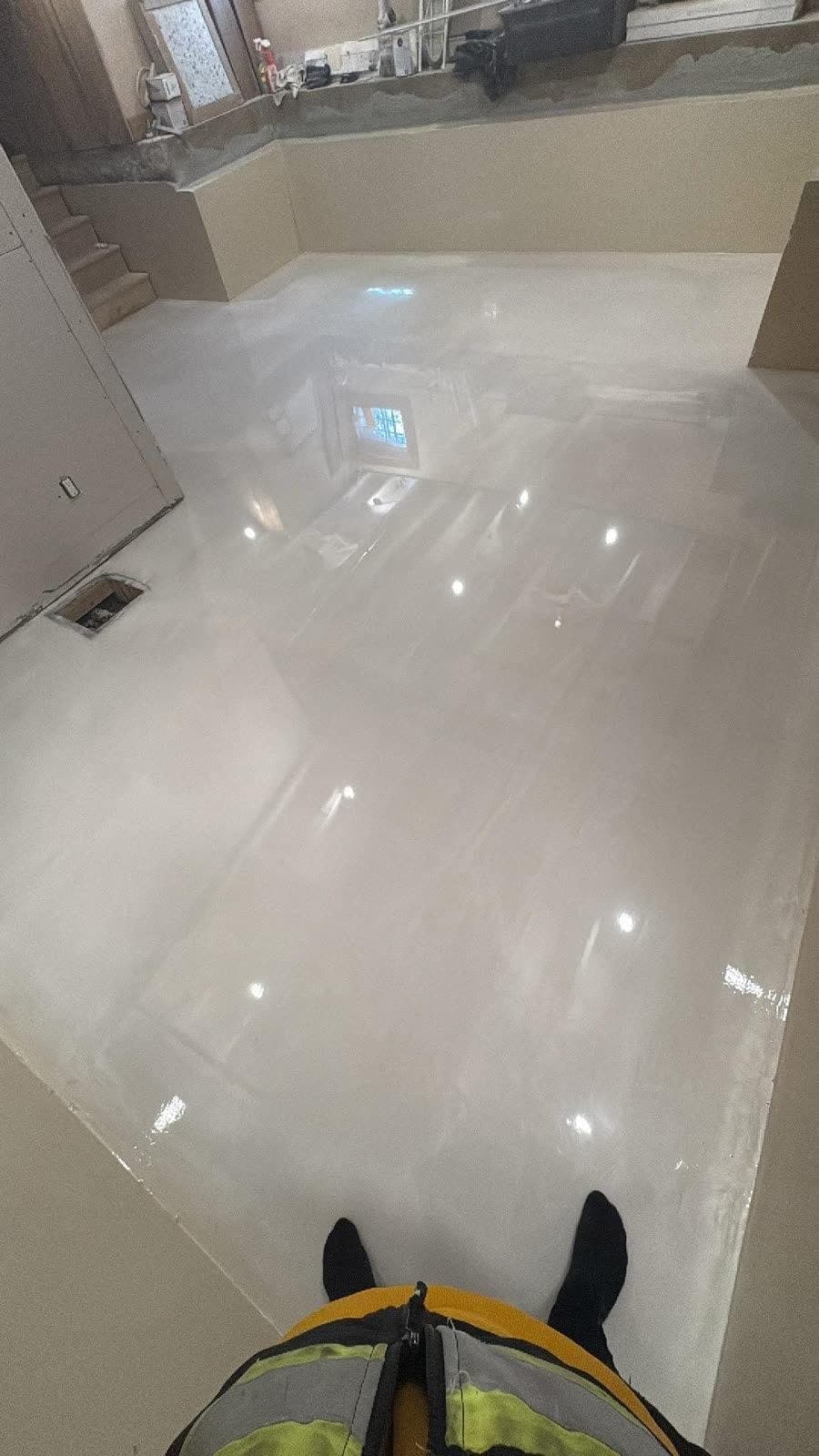 Plancher blanc lustré qui reflète la lumière d’une pièce