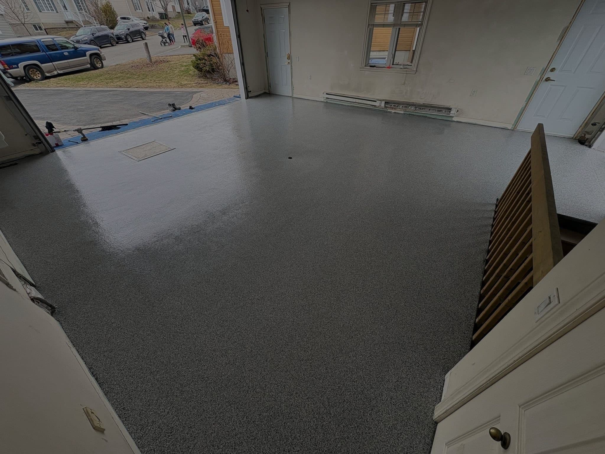 Garage finished in grey vinyl flakes, door open onto the driveway